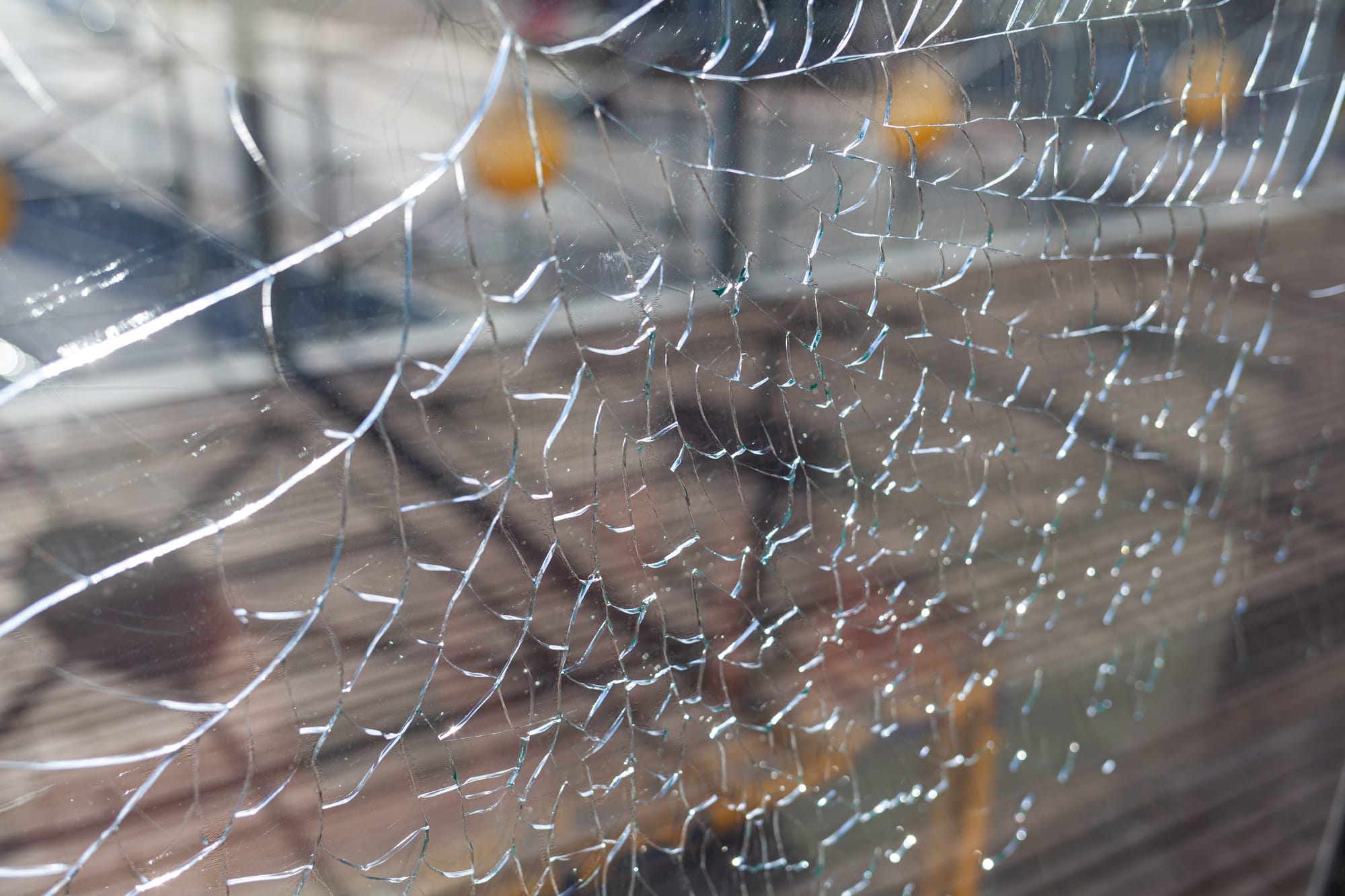 Broken glass, cracks on the window glass. There is a river and a city