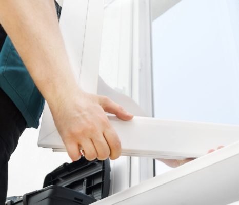Professional handyman installing window at home.